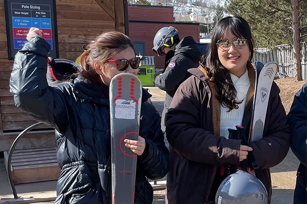 two students holding skis