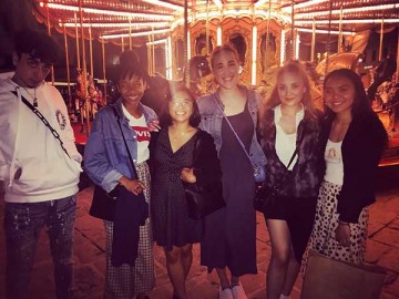 group of students standing in front of a merry go round