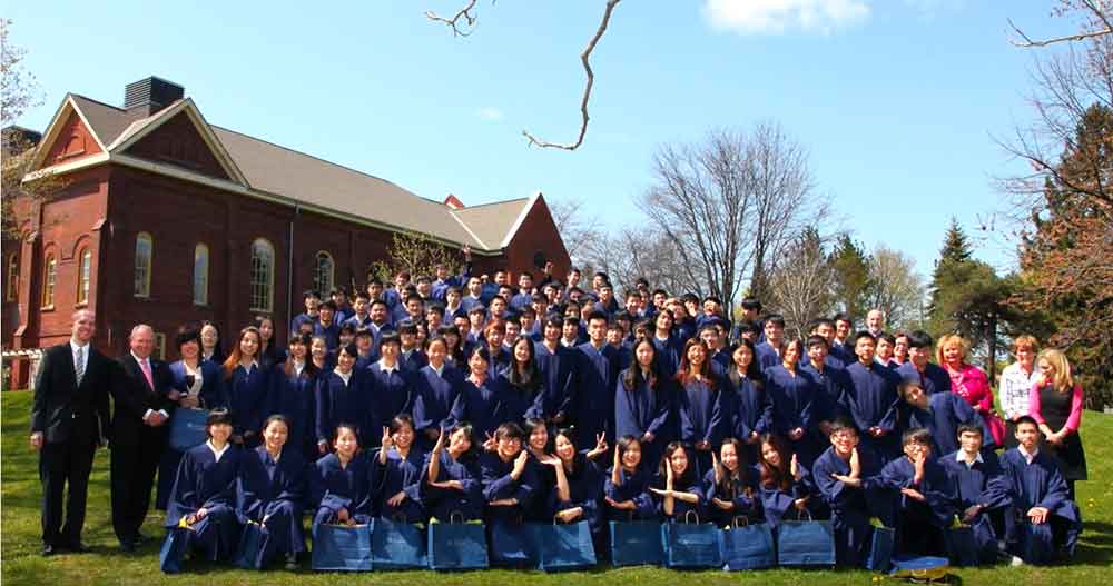 graduates outside at lakeshore campus in caps and gowns