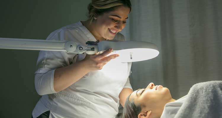 student doing a facial on young lady