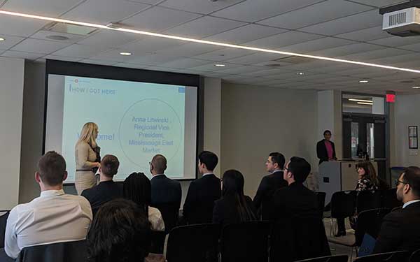 Group of people watching a woman present a lecture