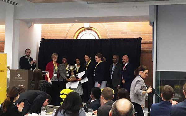 Group of people on stage receiving a trophy