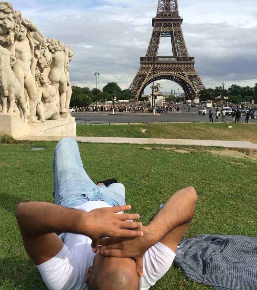 Nic laying next to the Eiffel tower