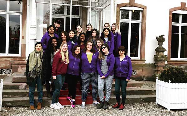 Students posing for picture on the steps of a building