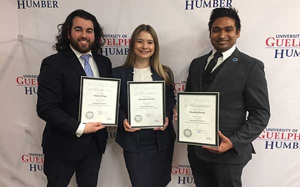 Three students holding awards