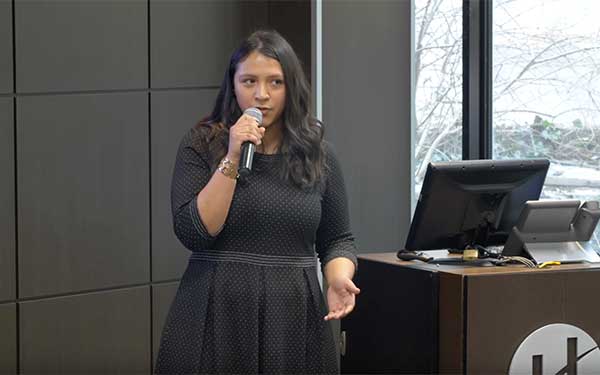Woman speaking into microphone while giving a presentation