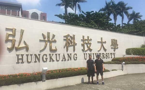 Two men standing outside of the Hungkuang University