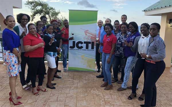 Group of people posing in front of a JCTI banner