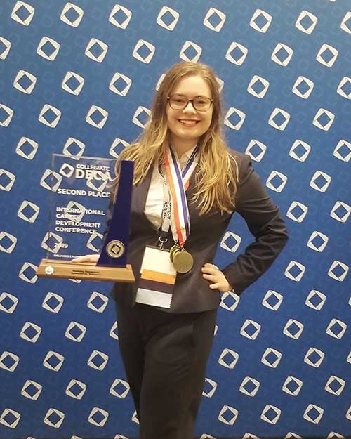 Student holding award