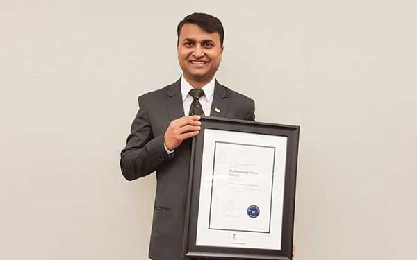 Man in suit holding a diploma