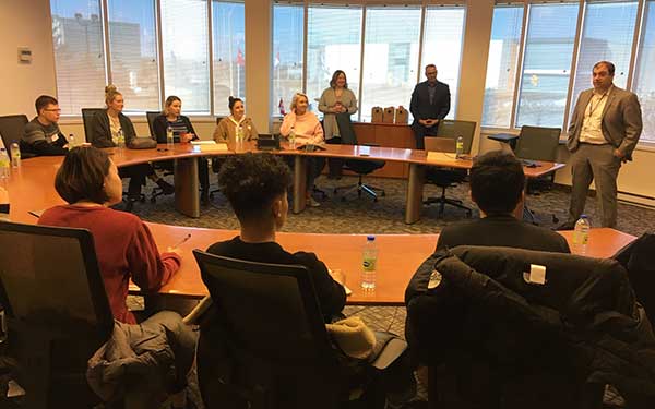 Fashion students gathered around a conference table