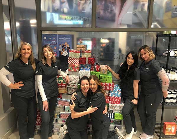 Humber Spa Team gathered around a pile of christmas gifts