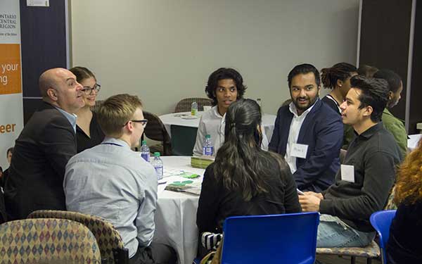 Group of students speaking to employeers