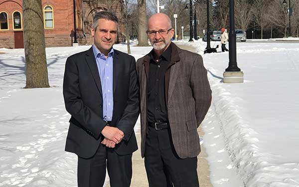 Two men standing outside in the snow